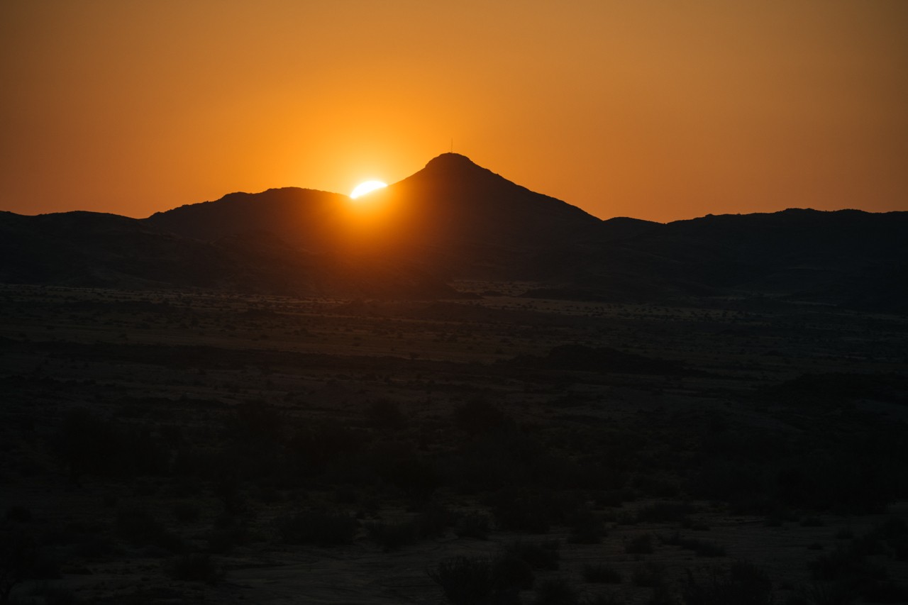 The sun sets behind the Karas mountains.