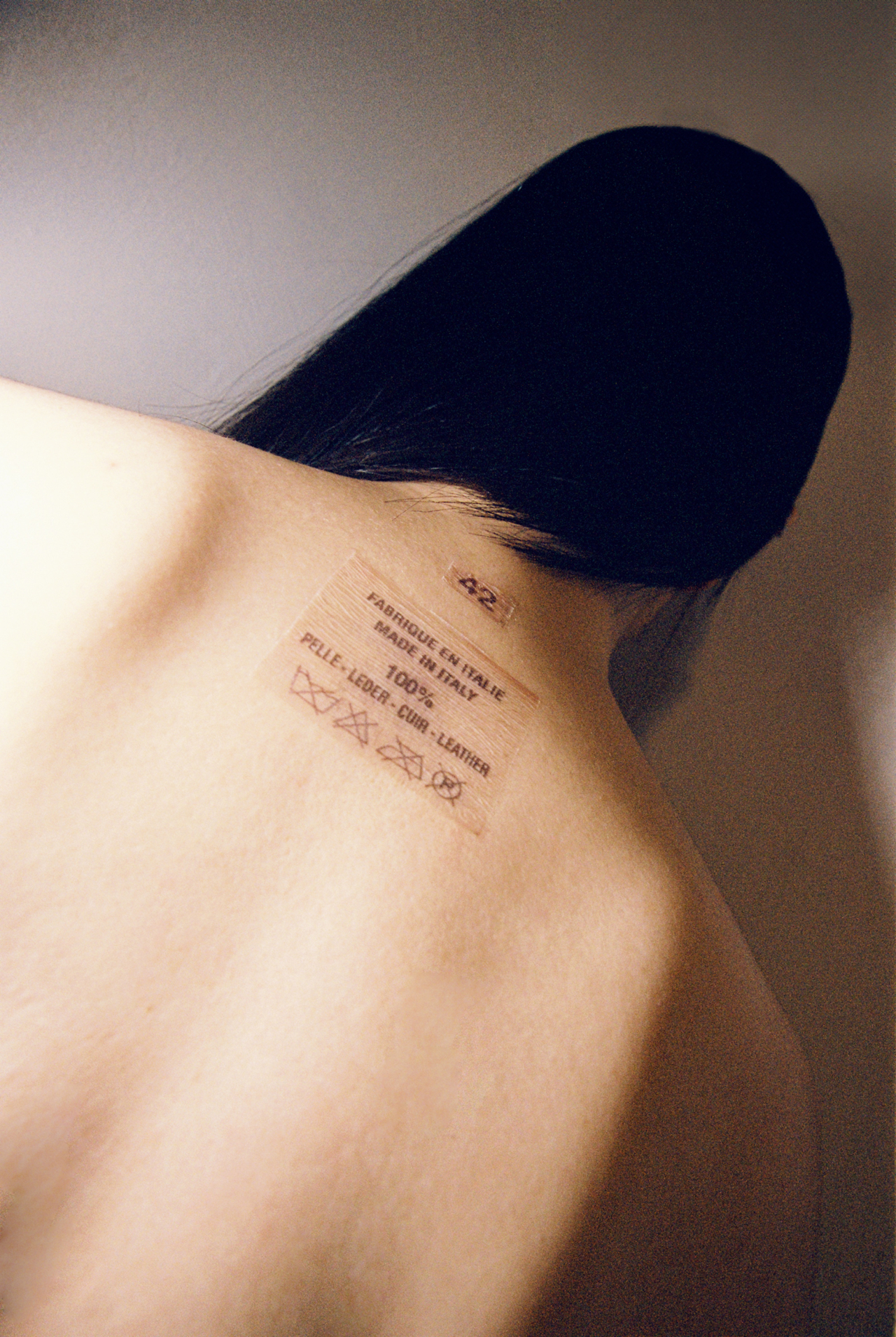 A translucent sticker of passport information on the nape of a person's neck.