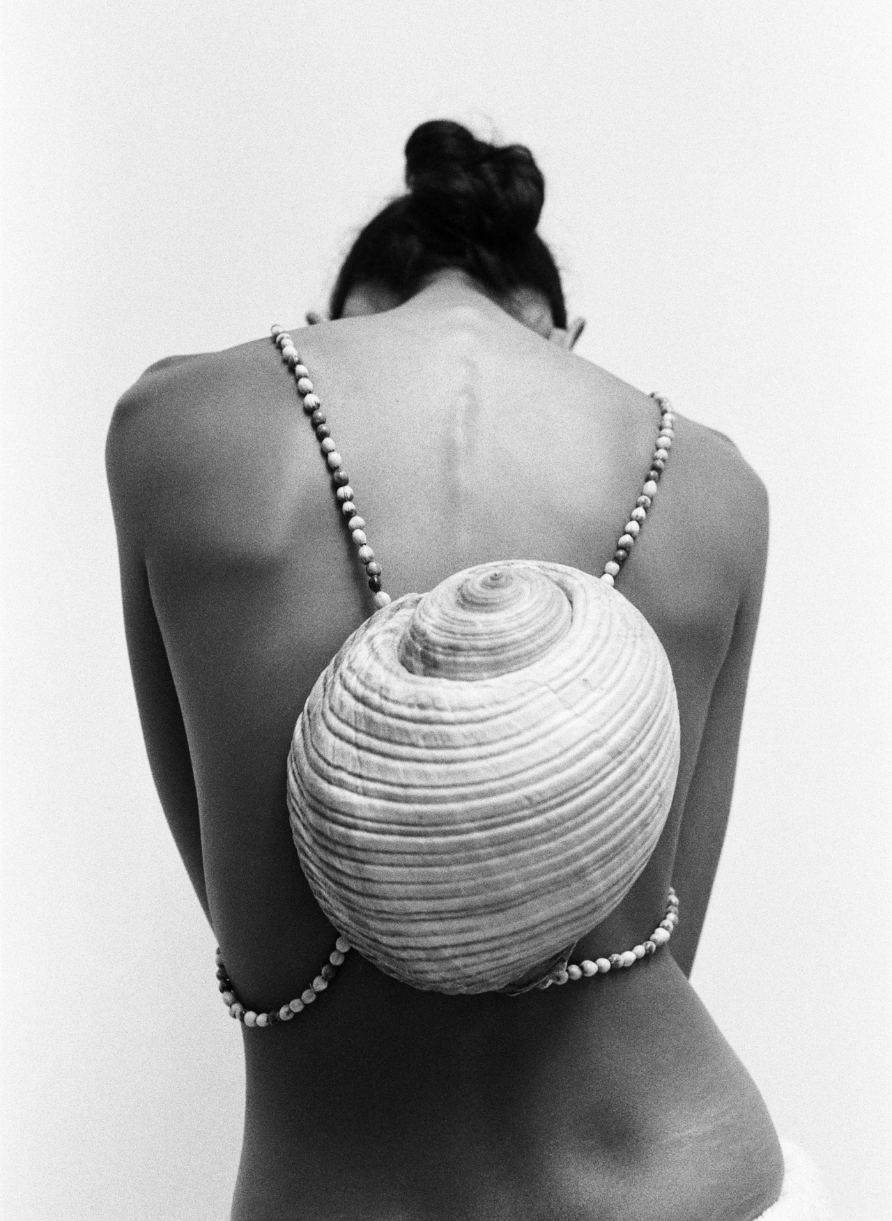 Padani wears custom-made backpack from shells and beads