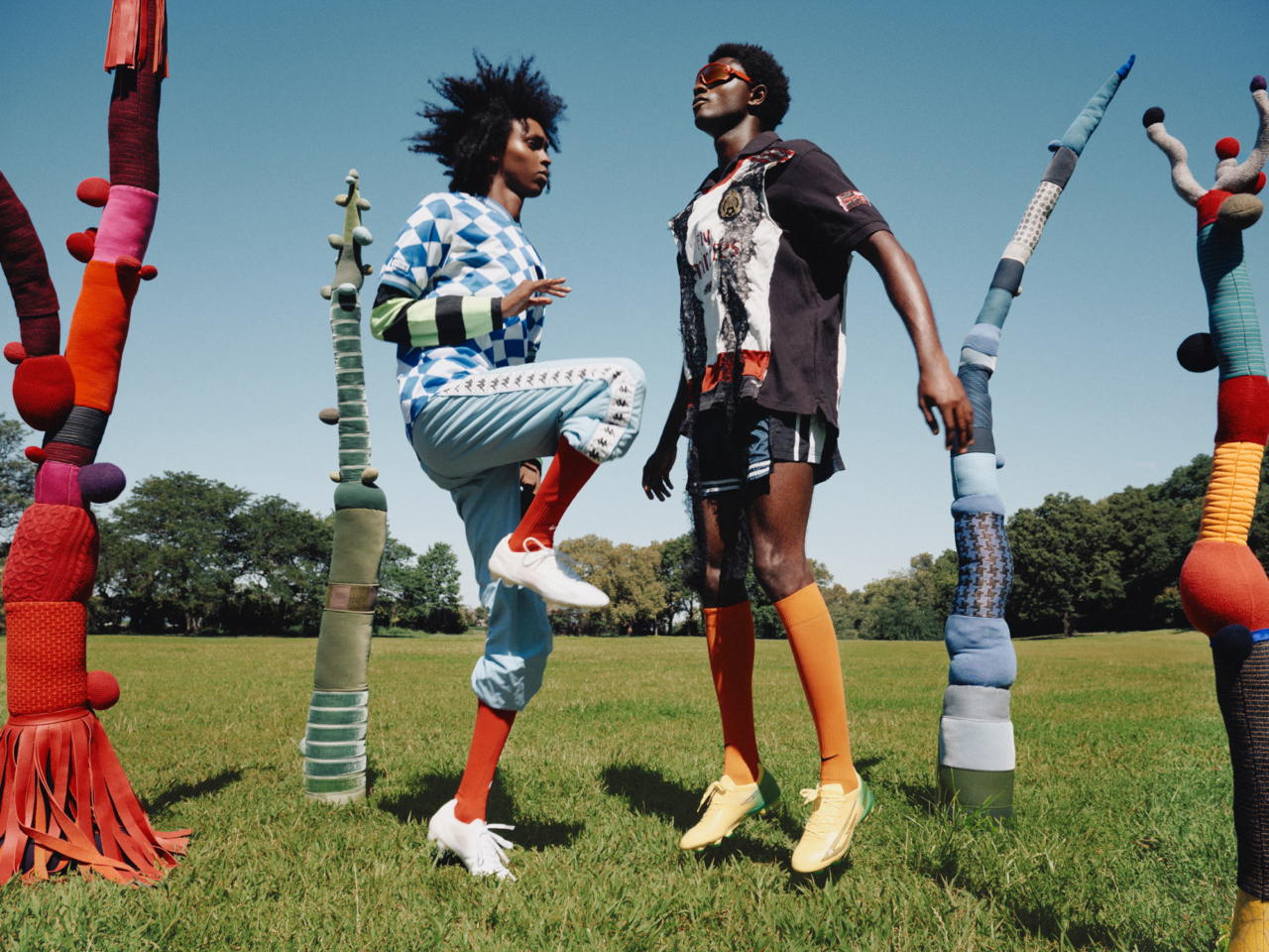 From left: Thursday wears vintage Umbro soccer jersey, vintage Nike soccer jersey, vintage Kappa pants, Nike soccer socks, Sokito boots. Samuel wears Sentimiento shirt and shorts, Nike soccer socks, Oakley sunglasses, Sokito boots Tree sculptures by Elodie Blanchard