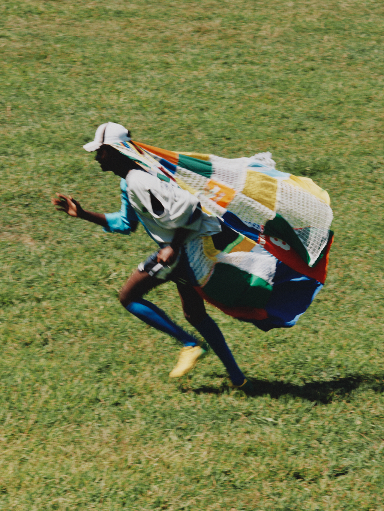 Samuel wears Sentimiento shirt, shorts, and cap, Nike soccer socks, Sokito boots