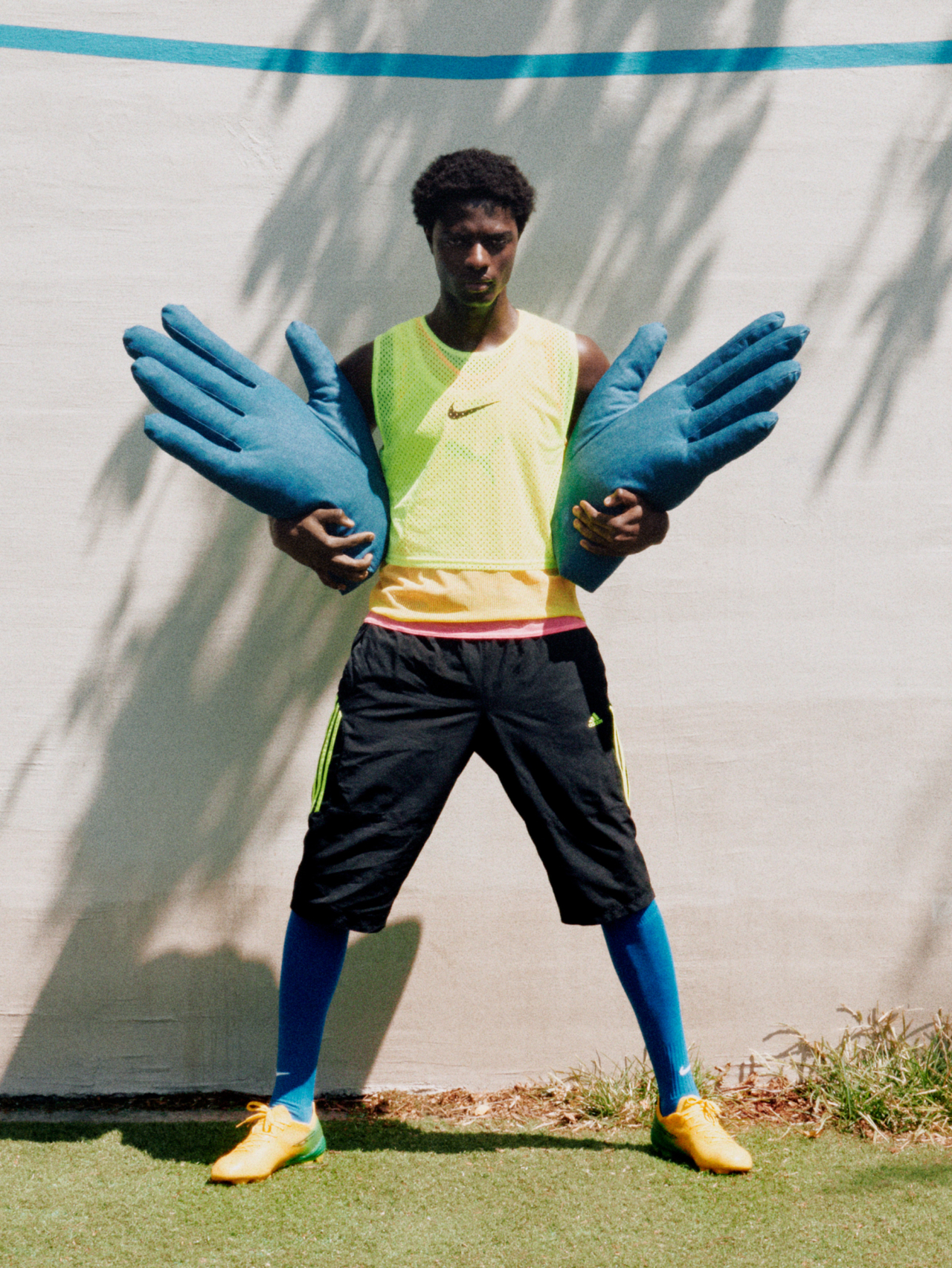 Samuel wears Nike, Adidas, and Puma soccer training bibs, vintage Adidas shorts, Nike soccer socks, Sokito boots Hands by Sohn made out of denim deadstock