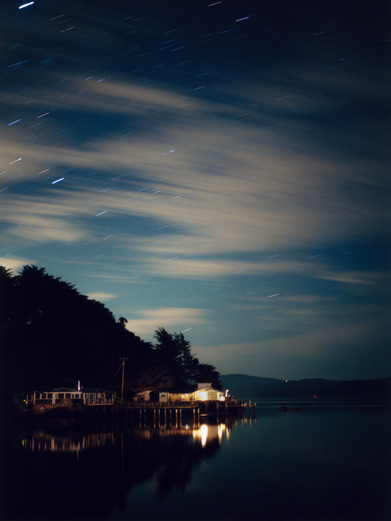 On a cloudy night at Nick’s Cove in Marin County, stars are still visible due to the lack of light pollution in the area.