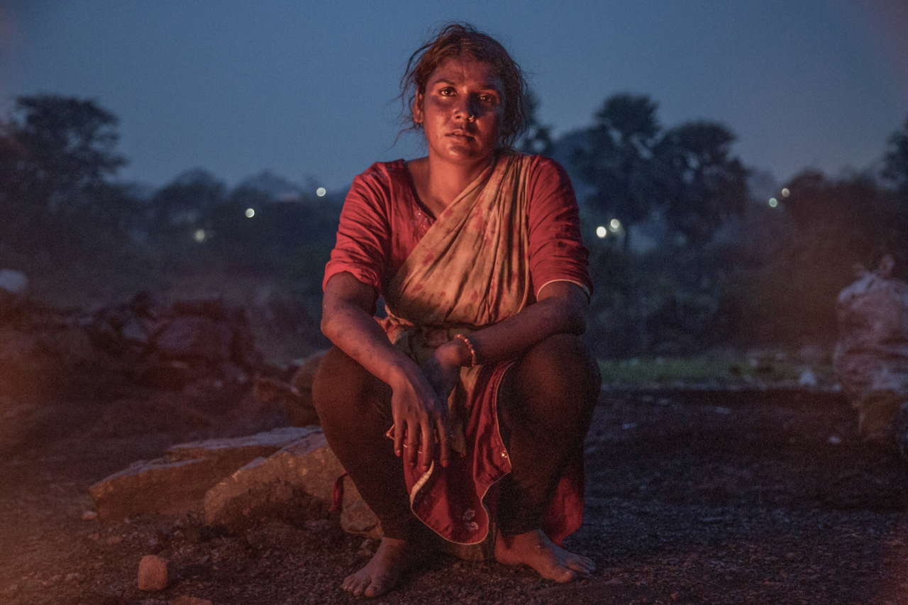 Beauty Devi (34) sits in her village in the evening after burning coal. Many abandoned mines with leftover coal were left unsealed and unsafe.