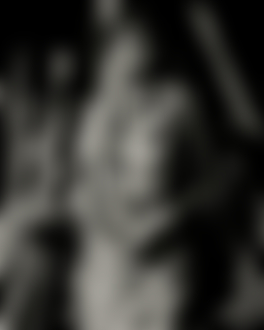 A woman from Odisha, India stands in front of a collection of tree bark.