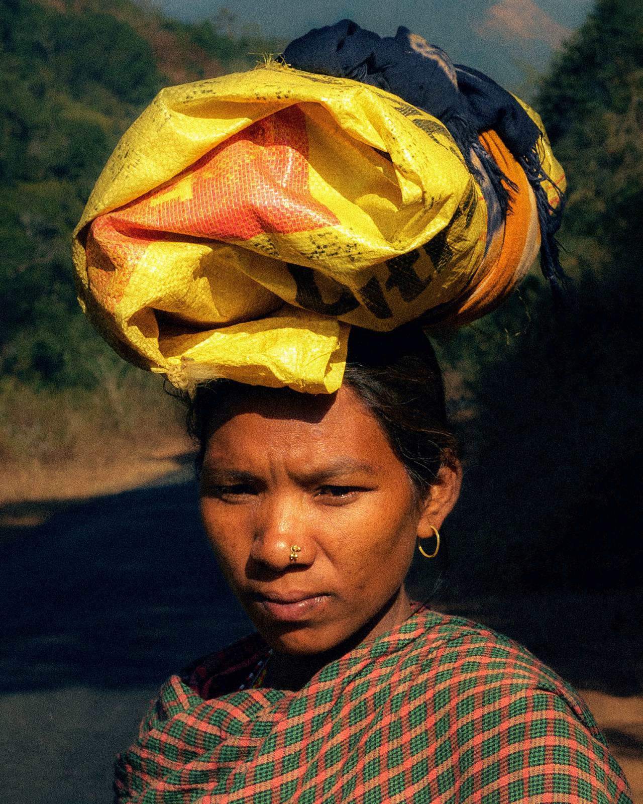 A woman from a Odisha, India carries a folded bag on top of her head.