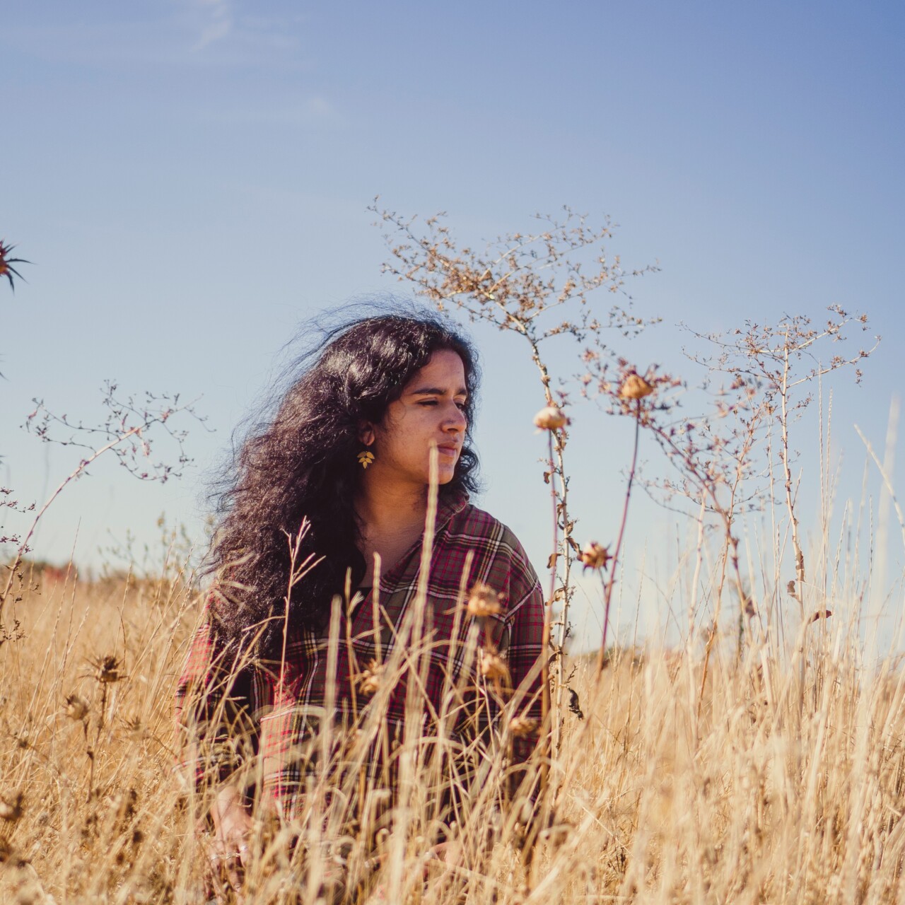 Ambika sits in a field.