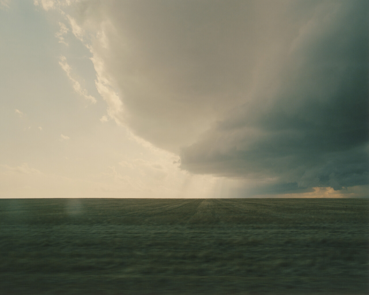 Rural field with big clouds overhead