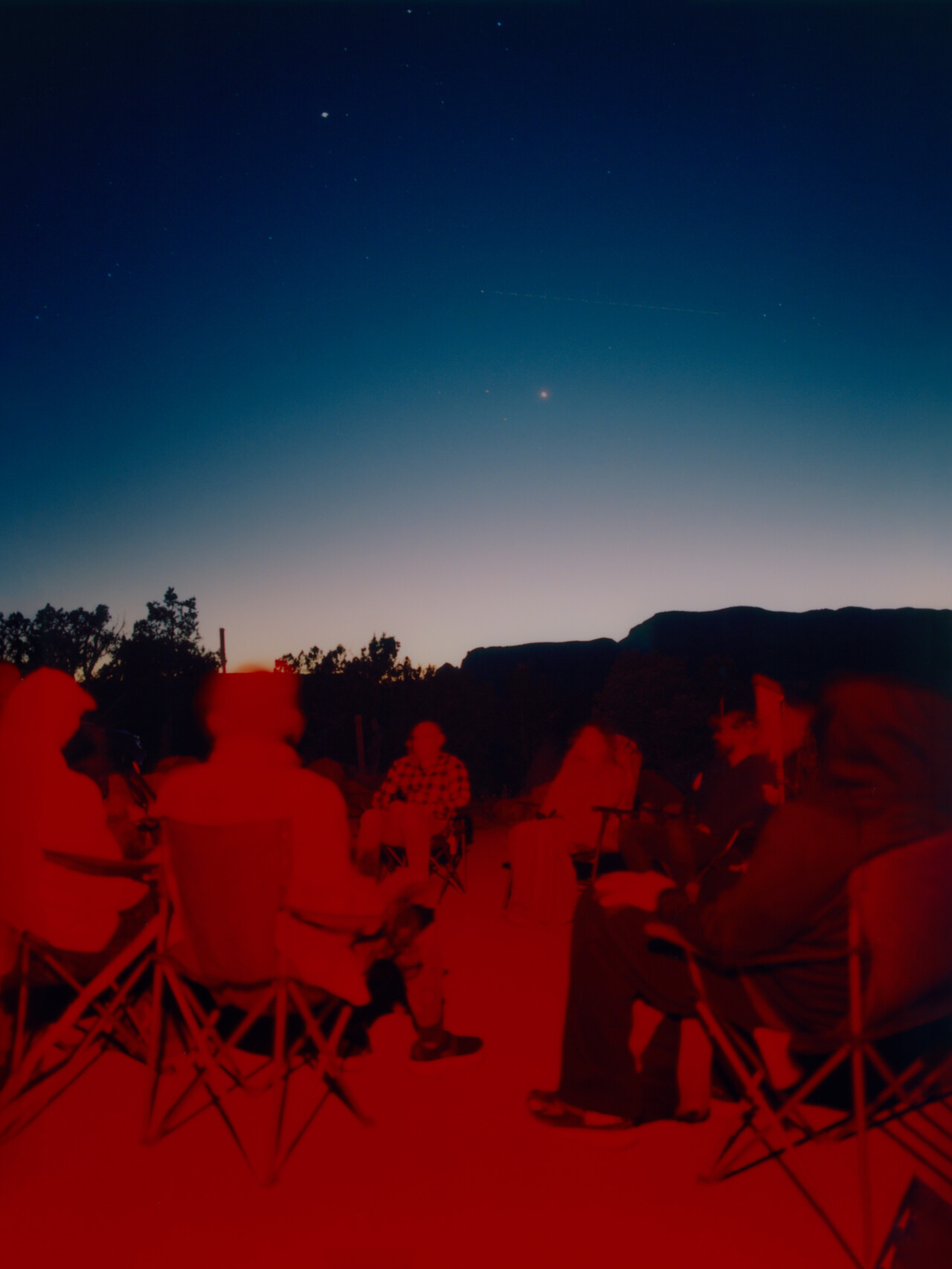 Participants gather under the night sky during a UFO tour in Sedona, AZ, scanning the horizon for unexplained aerial phenomena.