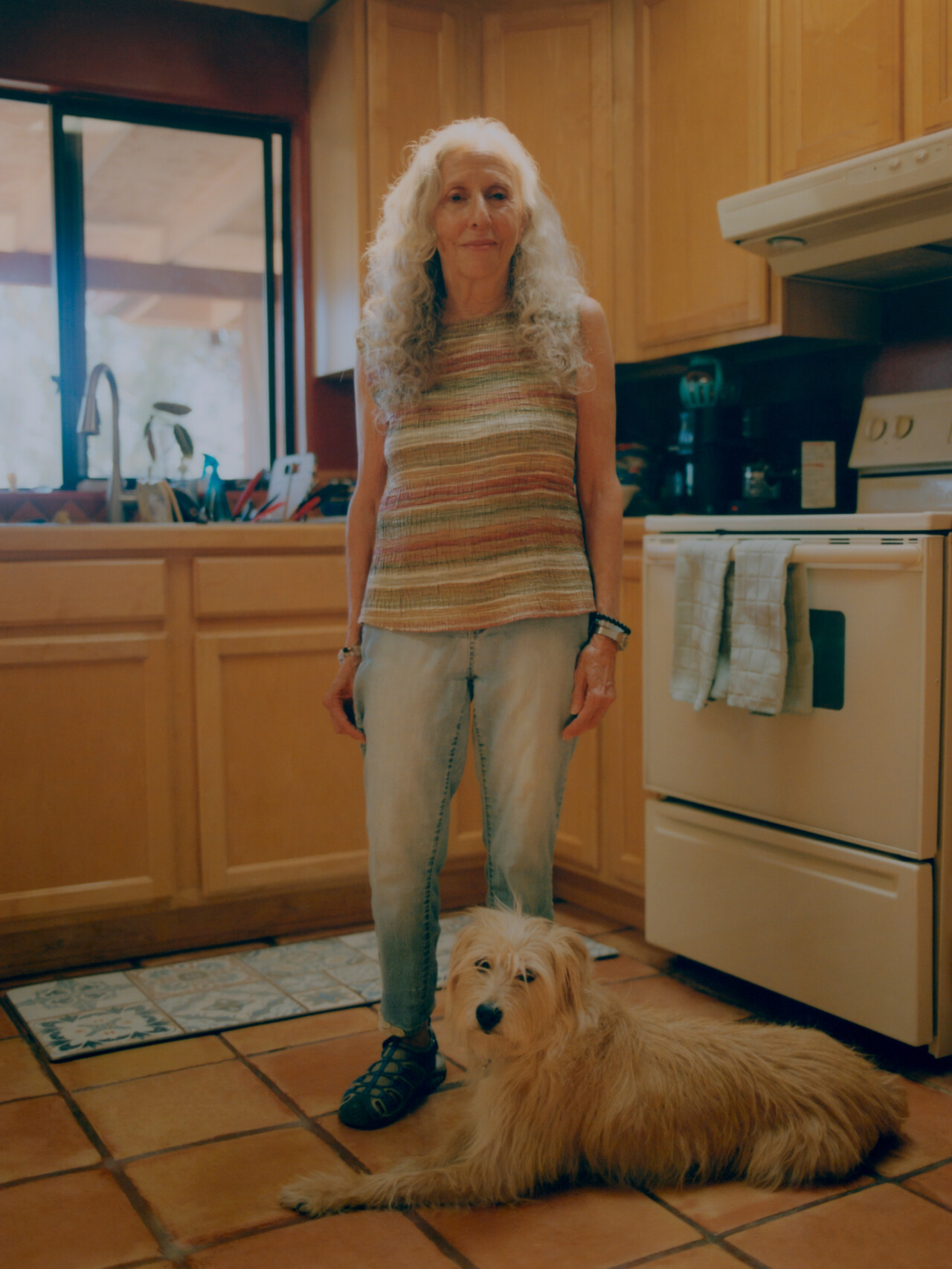 Susie Reed, a local UFO expert in Sedona, stands in her kitchen with her dog Patches.